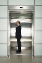 Businessman Adjusting Necktie In Elevator