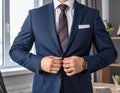 Businessman Adjusting Suit Jacket in Office Setting Royalty Free Stock Photo