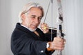 Businessman aiming at target with bow and arrow Royalty Free Stock Photo