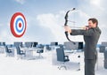 Businessman aiming at target with bow and arrow