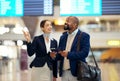 Businessman, airport and service agent pointing traveler to departure, flight time or information. Black male with