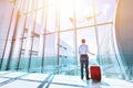 Businessman at airport terminal boarding gate looking at airplane flying Royalty Free Stock Photo