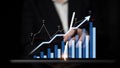 Businessman Analyzing Growth Data with Graphs and Charts on Digital Tablet in Dark Background, Representing Success and Royalty Free Stock Photo