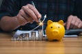 businessman analyzing forex trading graph financial data. coin in a piggy bank and arrows showing charts on his desk. Royalty Free Stock Photo