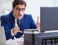 Businessman angry at copying machine jamming papers Royalty Free Stock Photo