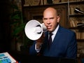 Businessman angry and furious shouts into a megaphone. Aggressive management concept Royalty Free Stock Photo