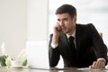 Businessman answering phone call at desk in office Royalty Free Stock Photo