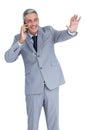 Businessman answering phone and waving Royalty Free Stock Photo