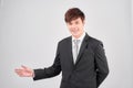 Businessman with arm out in a welcoming gesture over gray background Royalty Free Stock Photo