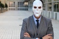 Businessman with arms crossed wearing a horrible mask Royalty Free Stock Photo