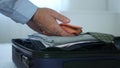 Businessman Arranges His Suitcase Preparing for a Business Trip