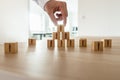 Businessman arranging wooden cubes with people silhouette in a p