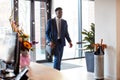 Businessman Arriving For Work At Office Walking Through Door