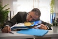 Businessman asleep from exhaustion on pile of folders and documents Royalty Free Stock Photo