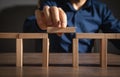 Businessman assembling a bridge made from wooden blocks