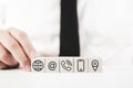 Businessman assembling white blocks with contact icons printed on them