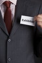 Businessman Attaching Exhibitor Badge To Jacket