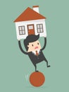 Businessman Balancing On The Ball With House On His Back