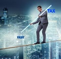 Businessman balancing between debt and tax Royalty Free Stock Photo