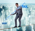 Businessman balancing between debt and tax Royalty Free Stock Photo