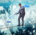 Businessman balancing between debt and tax Royalty Free Stock Photo