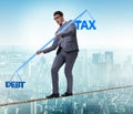 Businessman balancing between debt and tax Royalty Free Stock Photo