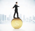 Businessman balancing on a gold coin