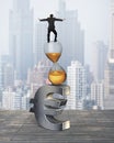 Businessman balancing on hourglass and euro sign