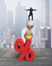 Businessman balancing on hourglass and red percentage sign