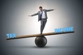 The businessman balancing between income and tax in business concept Royalty Free Stock Photo