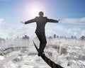 Businessman balancing on a wire with sun mist cityscape Royalty Free Stock Photo