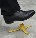 Man stepping on banana peel, skin in street, work accident, danger Royalty Free Stock Photo