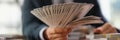 Businessman banker holding fan of dollar bills in hand closeup