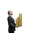 Businessman or banker holds in his arms many golden coins