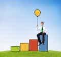 Businessman on a Bar Graph Holding a Balloon Royalty Free Stock Photo