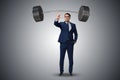 The businessman with barbell in heavy lifting concept