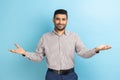 Businessman with beard sharing opening hands looking at camera with kind smile greeting and regaling