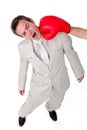 Businessman being hit with a boxing glove Royalty Free Stock Photo