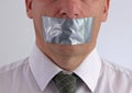 Businessman with duct tape over mouth