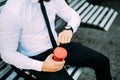 Close up Businessman On Bench With Coffee look at clock to be in time from pause at work