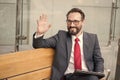 Manager on bench with tablet welcome colleagues out of office. Professional business people meeting outdoor. Happy Bearded man Royalty Free Stock Photo