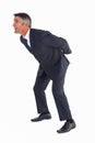 Businessman bending with arms on his back