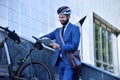 Businessman with bicycle, helmet and using digital tablet computer