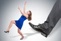 Businessman big foot kicking small business woman Royalty Free Stock Photo