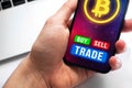 Businessman with bitcoin buy and sell trade application on mobile phone, laptop background photo