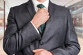 Businessman in black adjusting his tie in shopping center Royalty Free Stock Photo