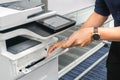 Businessman with black shirt put paper sheet into printer feeder for copying documents Royalty Free Stock Photo