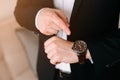 Businessman in black suit look at his expensive swiss wristwatch on his hand and watching the time Royalty Free Stock Photo