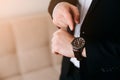 Businessman in black suit look at his expensive swiss wristwatch on his hand and watching the time Royalty Free Stock Photo