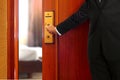 Businessman in black suit opening hotel room door